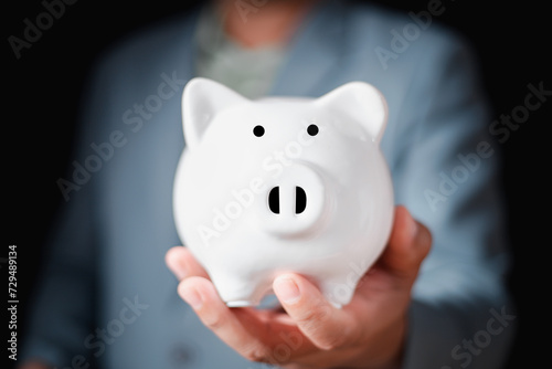 Close-up Of Businessman Hand holding white Piggybank, Financial planning and saving money, Money saving concept for the future plan and retirement fund.