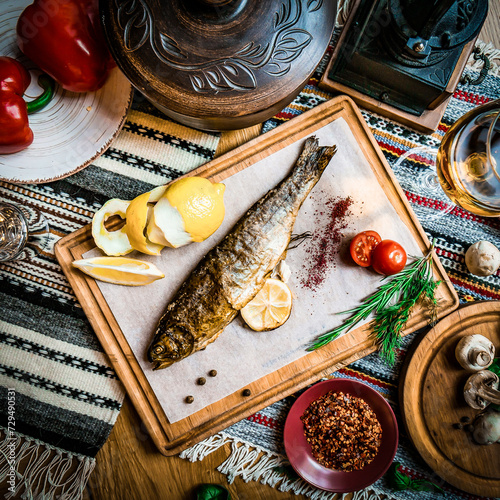 Turkish or Greek restaurant table and food dinner cuisine culture from top view. Traditional Greek ouzo or turkish raki with grilled or fried fish and appetizers on dinner table at restaurant. photo