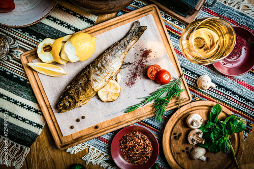 Turkish or Greek restaurant table and food dinner cuisine culture from top view. Traditional Greek ouzo or turkish raki with grilled or fried fish and appetizers on dinner table at restaurant. photo