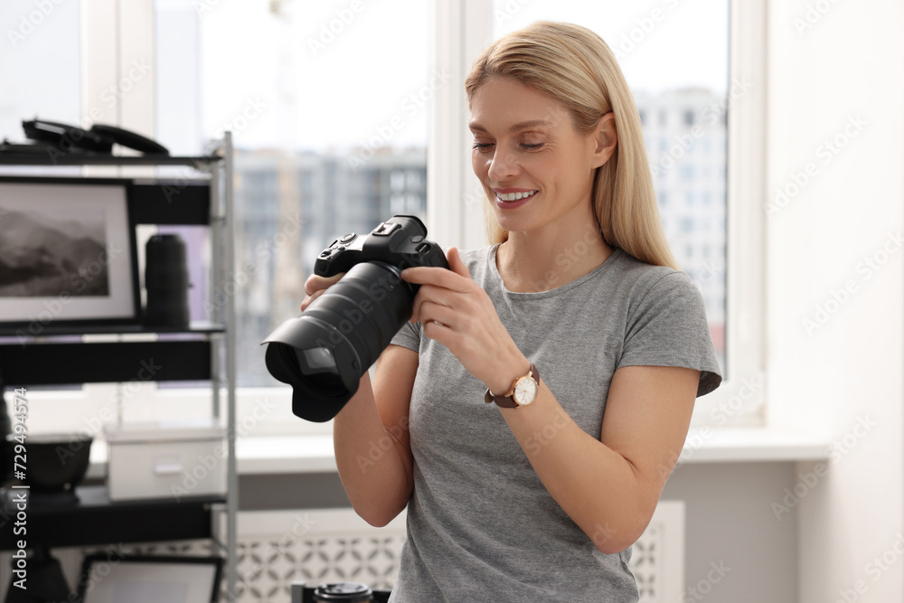 Professional photographer with modern digital camera in office