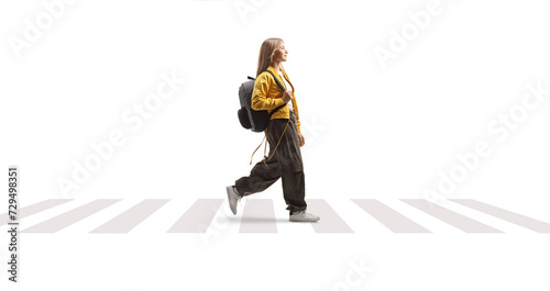Obraz na płótnie Female teenage student with a backpack walking over a pedestrian crossing