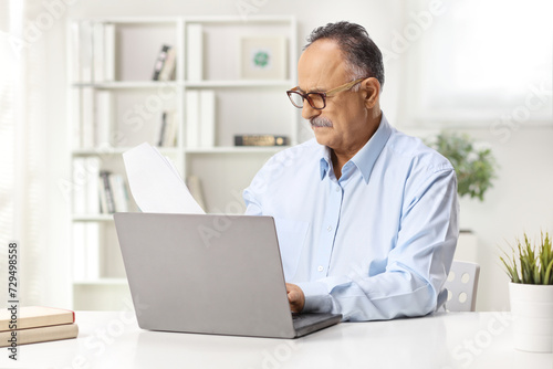 Mature man sitting in an office and working on a laptop
