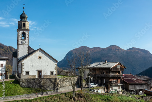 Scenic view of remote alpine village of Sauris di Sotto in Carnic Alps, Friuli Venezia Giulia, Italy. Serene tranquil atmosphere in Italian Alps. Traditional wooden houses and church of Saint Oswald