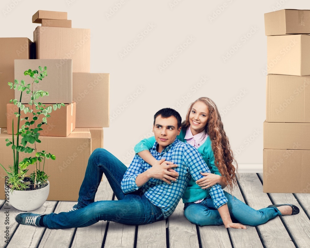 Portrait Of Smiling Young Couple Among Boxes in New Home Portrait Of Smiling Young Couple Among Boxes in New Home