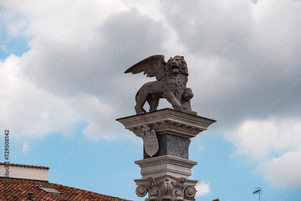 Statue of San Marco lion on the top of column outside the 16th century Renaissance Loggia di San Giovanni in Udine, Friuli Venezia Giulia in Italy. Landmark on town main square Piazza della Liberta