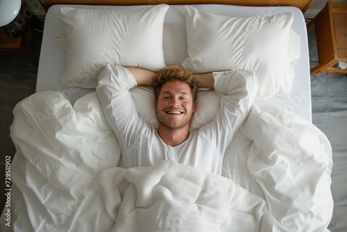 Smiling Man Relaxing in Bed with Arms Behind Head