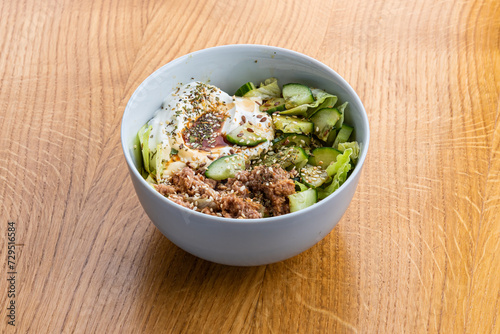 Bowl with tuna on a wooden table
