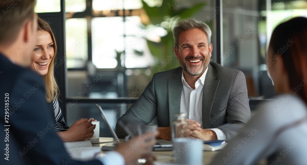 Smiling businessman with another diverse businesspeople having a discussion while collaborating on a new project in an corporate office. Smiling businessman with another diverse businesspeople having a discussion while collaborating on a new project in an corporate office.