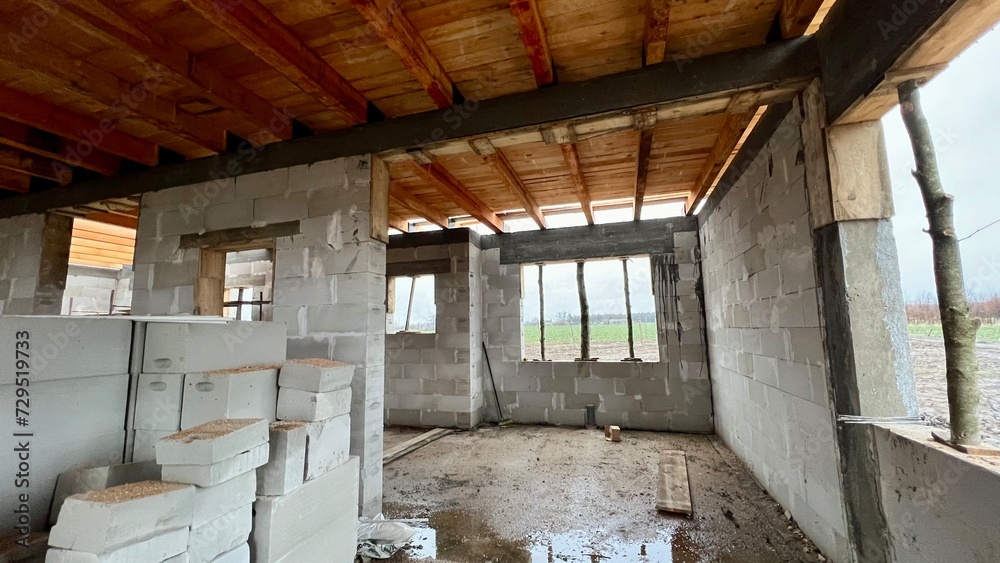 a lot of building concrete blocks inside the house construction side. Building in progress with mason work and wooden ceiling done. a lot of building concrete blocks inside the house construction side. Building in progress with mason work and wooden ceiling done.
