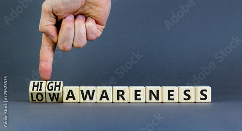 High or low awareness symbol. Concept words High awareness Low awareness on wooden blocks. Beautiful grey table grey background. Businessman hand. Business High or low awareness concept. Copy space.