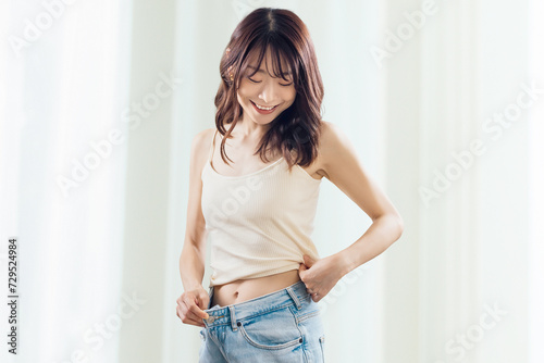 Photography ダイエットに成功して喜ぶ女性、ウエストサイズダウンのボディメイクイメージ, Happy woman celebrating weight loss succes
