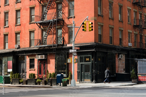 Obraz na płótnie A beautiful corner view of an old building with a classic red brick wall facade and an iron fire escape in New York City w salonie