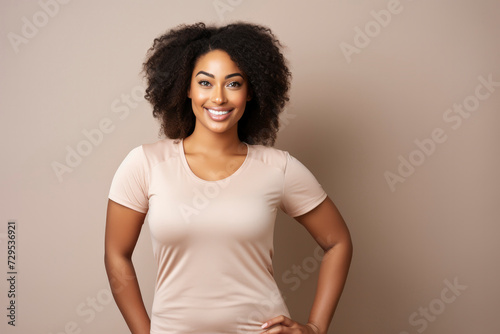 Beautiful young African American woman with curly hair smiling in light clothes against a light background. Happy girl, human emotions