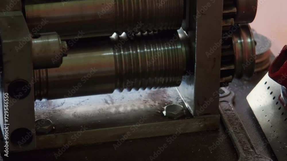 Goldsmith using a press to roll silver ring blank. Close up. Jewelry handicraft Goldsmith using a press to roll silver ring blank. Close up. Jewelry handicraft
