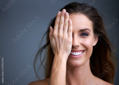 Woman, portrait and face for makeup, beauty or skincare in anti aging or cosmetics on a gray studio background. Happy, half and female person with smile in satisfaction for facial treatment on mockup