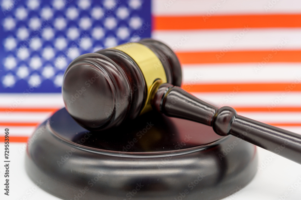 Justice Under the Stars and Stripes. A judge’s gavel rests on a sound block against the backdrop of an American flag, symbolizing law and order in the United States