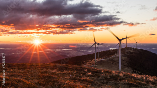 A group of wind power plants early in the morning while sunrise in Austria