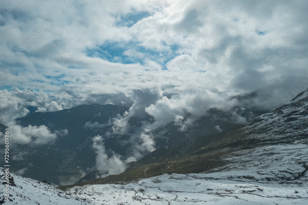 Panoramic view from mountain peak Arnoldhoehe in Ankogel Group, High Tauern National Park, Austria. Wanderlust in untamed snow covered Austrian Alps. Cloud covered terrain in idyllic hiking atmosphere