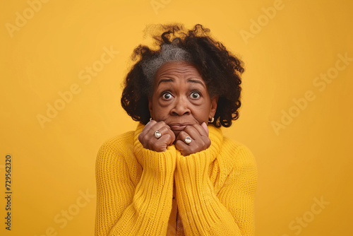 Nervous senior African American woman in studio with oops reaction on yellow background. Mistake, sorry, drama or secret with regret, shame or awkward