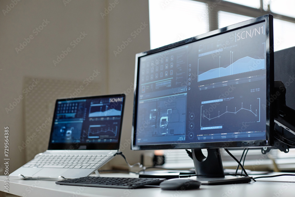 Close up background image of computers on desk in cybersecurity office with data screens reflecting light copy space Close up background image of computers on desk in cybersecurity office with data screens reflecting light copy space
