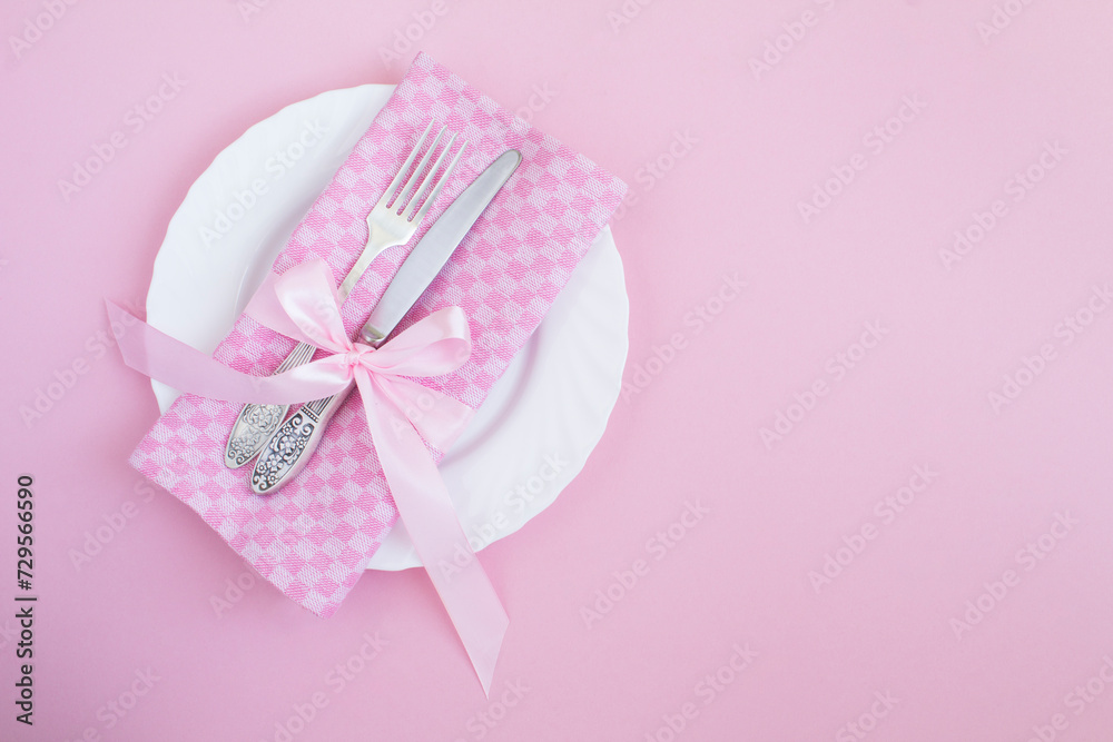 Table setting with pink napkin in the pink background. Top view. Copy space. Table setting with pink napkin in the pink background. Top view. Copy space.