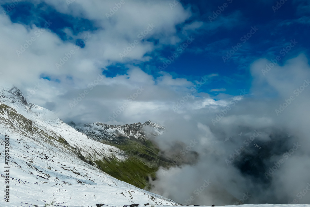 Panoramic view from mountain peak Arnoldhoehe in Ankogel Group, High Tauern National Park, Austria. Wanderlust in untamed snow covered Austrian Alps. Cloud covered terrain in idyllic hiking atmosphere Panoramic view from mountain peak Arnoldhoehe in Ankogel Group, High Tauern National Park, Austria. Wanderlust in untamed snow covered Austrian Alps. Cloud covered terrain in idyllic hiking atmosphere