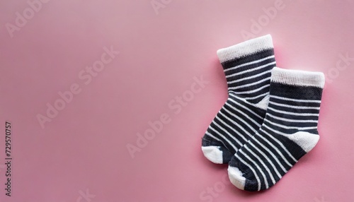 pair of small baby socks on pink background with copy space for your warm message baby shower first newborn party background copy space cute minimal postcard