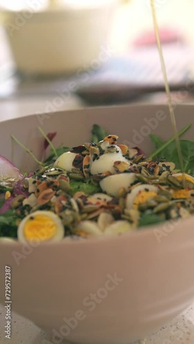 Very healthy and varied salad with olive oil dripping on the seeds in a vertical video for social networks.