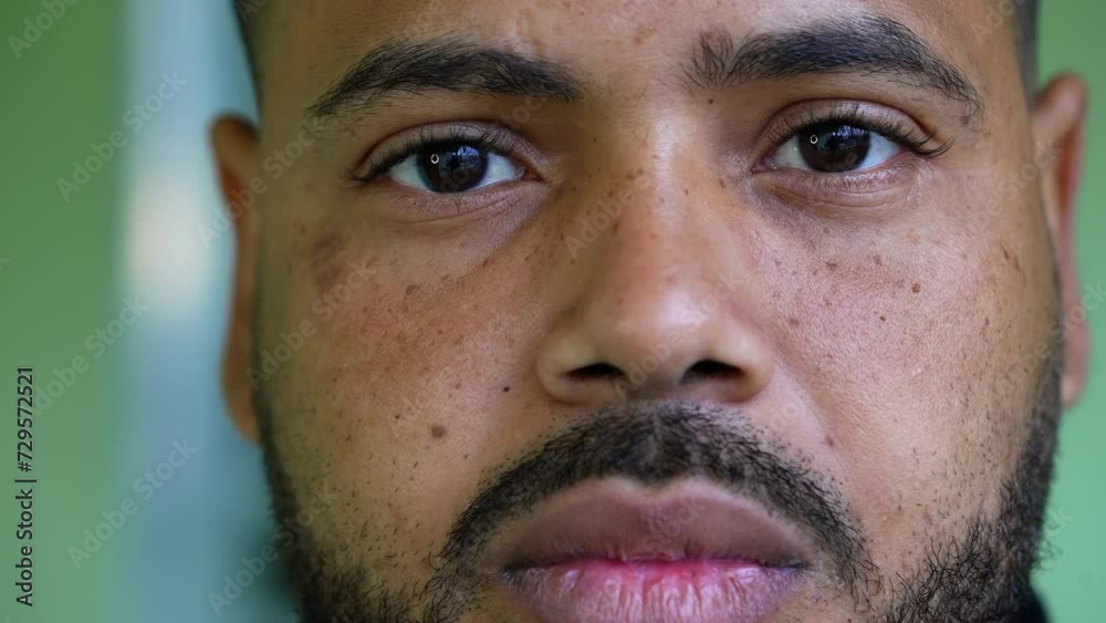 One young black latin man from South American close-up in macro. Portrait of a Brazilian hispanic man staring at camera with neutral solemn expression One young black latin man from South American close-up in macro. Portrait of a Brazilian hispanic man staring at camera with neutral solemn expression