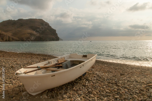 Una barca de remos tradicional varada en la playa. Playa de Las Negras al amanecer con el conocido como colina Negra al fondo. Almer  a  Andaluc  a  Espa  a.