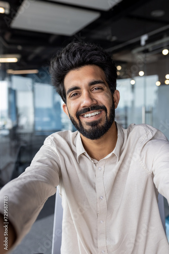 Smiling indian businessman in casual shirt at modern office space