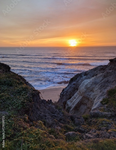 glow of sunset colors painting the rugged cliffs and the endless horizon of the Pacific Ocean 