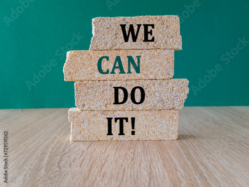 We can do it symbol. Concept words We can do it on brick blocks. Beautiful green background, wooden table. Business and We can do it concept. Copy space.