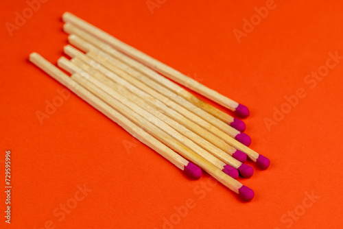 matches with a red pink substance for lighting on an orange background