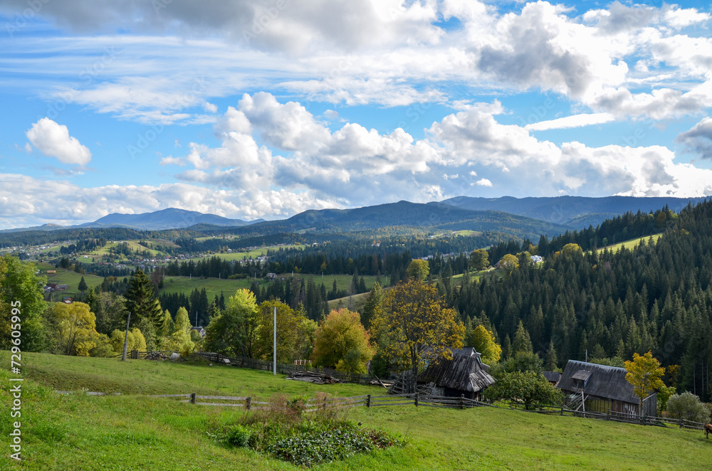 Picturesque landscape with a view of the mountain landscape, green meadows and forest. Rural houses located on the slopes of the mountains. Carpathians, Ukraine 