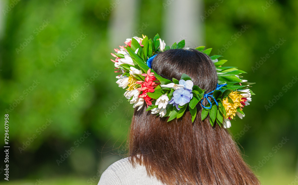 Naklejka premium Femme de dos avec sa couronne de fleurs sur la tête en Polynésie 