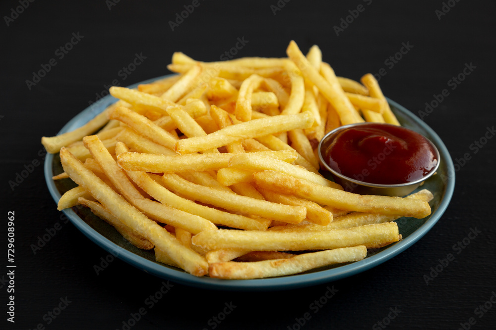 Homemade French Fries with Ketchup on a Plate, side view. Close-up. Homemade French Fries with Ketchup on a Plate, side view. Close-up.