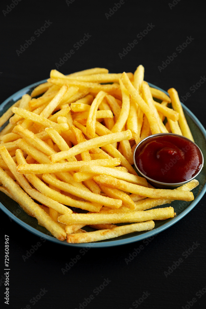 Homemade French Fries with Ketchup on a Plate, side view.