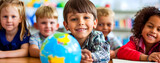 A child in a school class, behind a globe