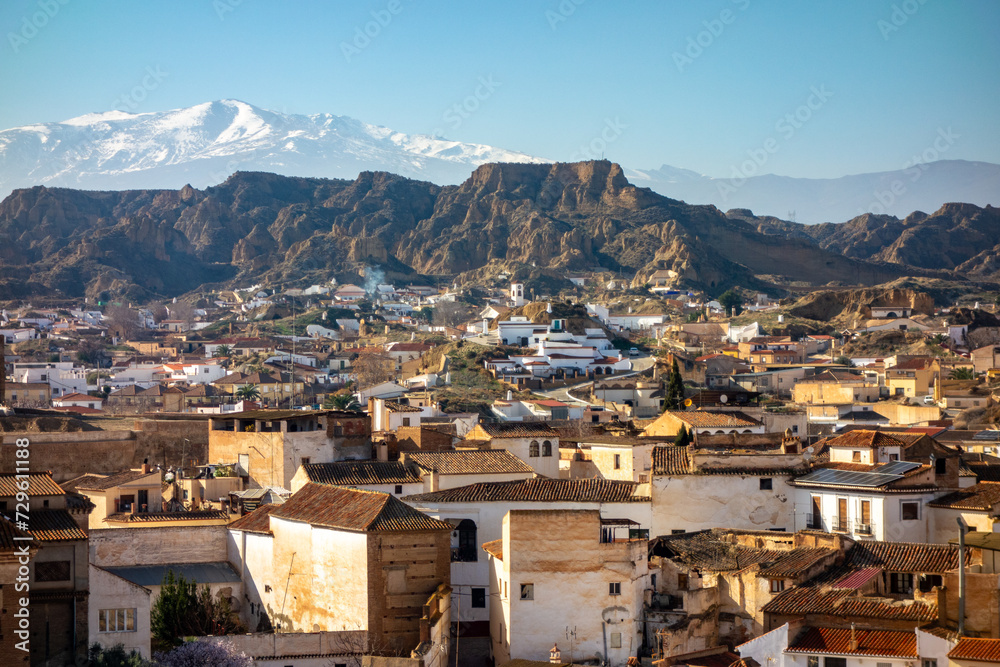 Spain, Guadix, view on town of cave houses and Sierra Nevada mountains covered by snow