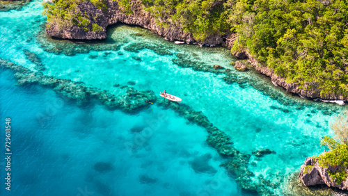 Aerial view of spear fishing boat in Fiji along coral reef.