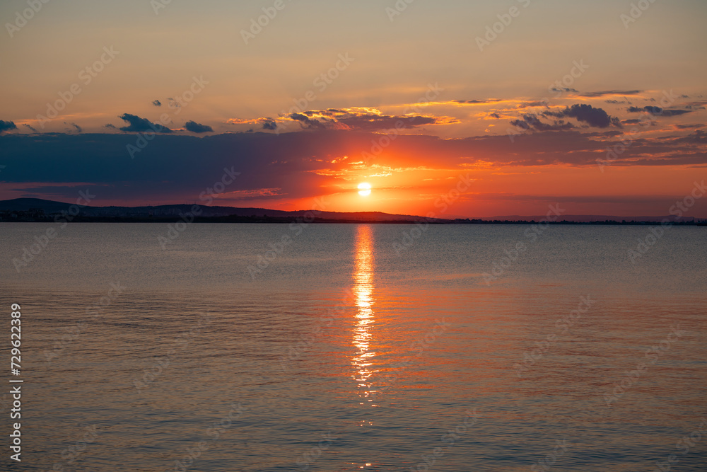 Fototapeta premium Incredible amazing, colorful summer sunsrise in Bulgaria Black coast. Orange sunset sky and reflection in the blue water.