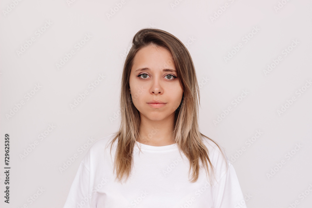 Portrait of a young attractive charming caucasian blonde woman in a white t-shirt isolated on a light background Portrait of a young attractive charming caucasian blonde woman in a white t-shirt isolated on a light background