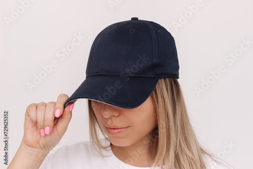 Photography Young caucasian blonde woman holding the visor of the cap showing empty copy spa