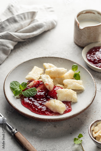Lazy dumplings, vareniki with raspberry jam decorated with almond petals and mint leaves. Boiled cottage cheese homemade gnocchi