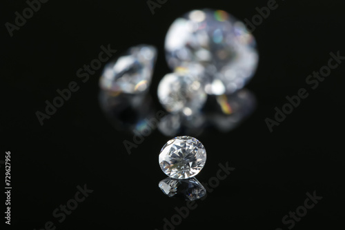 Beautiful shiny diamond on black mirror surface