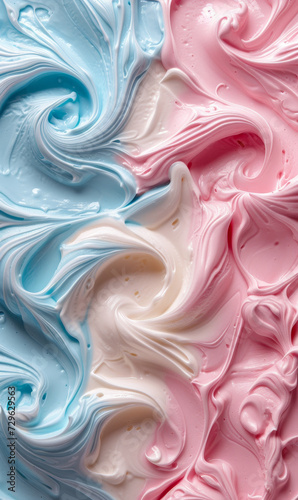 Top view of swirls of ice cream in pastel pink and blue shades with a creamy texture.