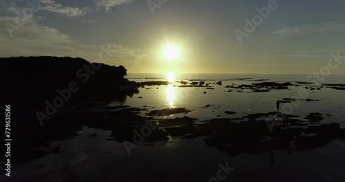 Aerial footage of the amazing beach of Jisr az-Zarqa with fishermen fishing in the water, in front of a stunning sunset. photo