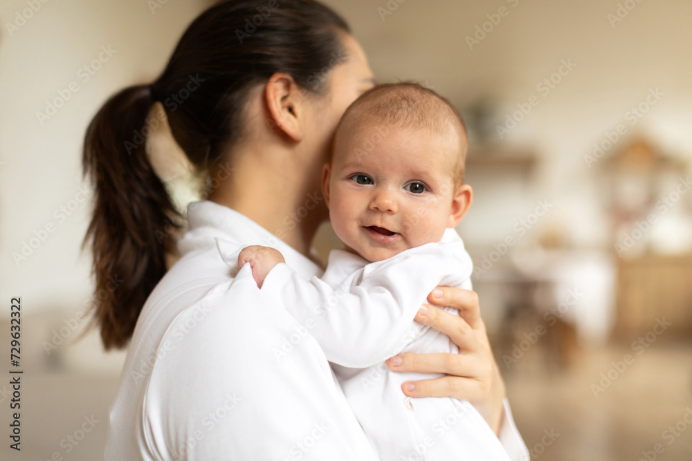 Mother carying her newborn baby girl at home, playing and enjoying time with kid. Childcare, maternity concept Mother carying her newborn baby girl at home, playing and enjoying time with kid. Childcare, maternity concept