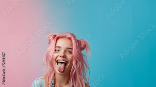 Hipster Girl in pink hair shows her tongue. smiling pretty girl sticking out tongue. Funny humorous young woman showing tongue at camera as if teasing someone, having playful look photo